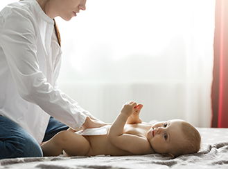 Professional caregiver changing baby's diaper